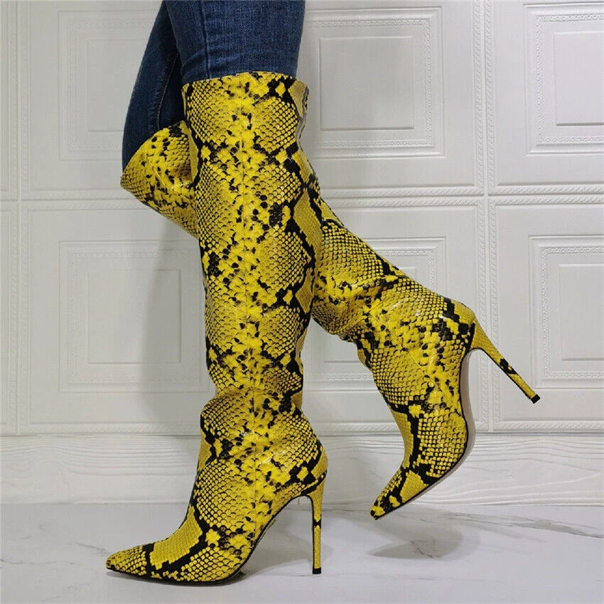 Yellow python-print thigh-high stiletto boots against a white panelled wall